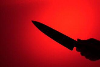 silhouette of hand holding knife on red background video